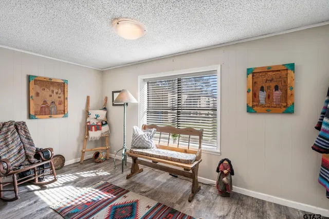 a bedroom with a bed and a dresser with wooden floor