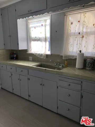 a bathroom with a granite countertop sink mirror and window