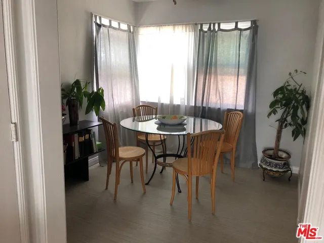a dining room with furniture and a potted plant