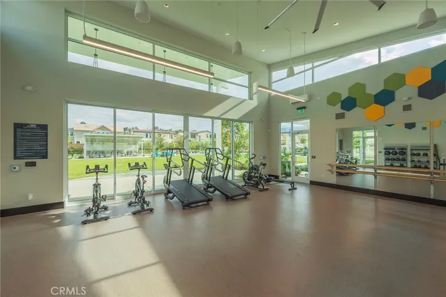 a gym with large windows and view of living room