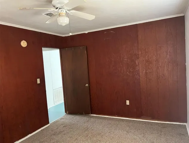 an empty room with closet and chandelier fan
