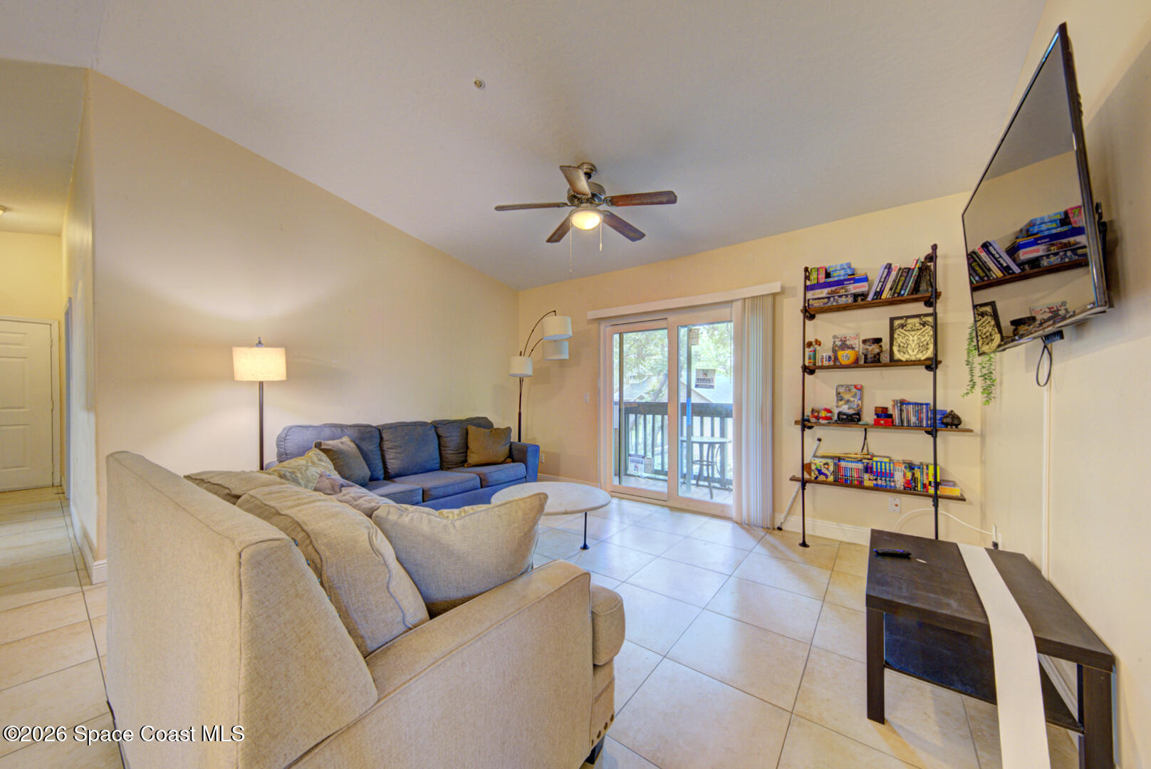 7667 North Wickham Road, Unit 1416 Melbourne, FL 32940 - Photo 17 of 41 a living room with furniture a window and a flat screen tv