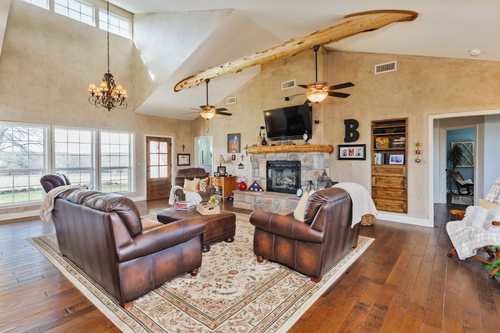 4460 Hildreth Pool Road Bowie, TX 76230 - Photo 5 of 40 a living room with furniture a fireplace and a ceiling fan