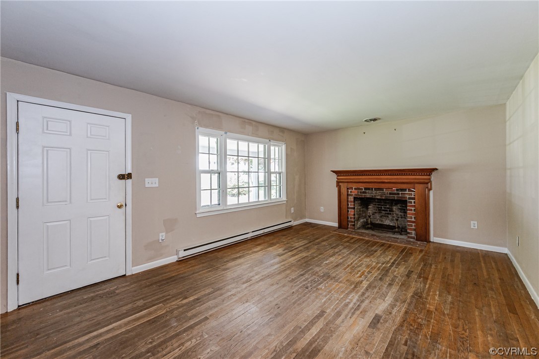 6713 Cherry Road Quinton, VA 23141 - Photo 6 of 50 an empty room with wooden floor fireplace and windows