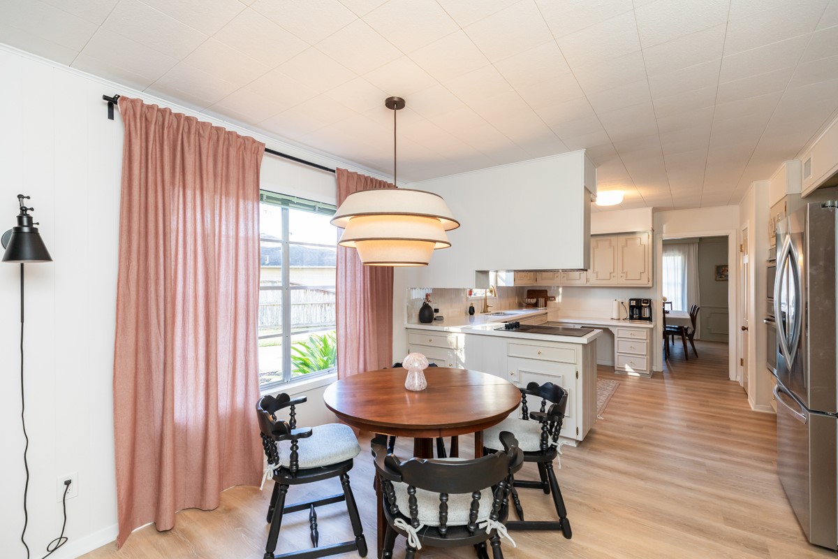1210 Nottingham Lane Beaumont, TX 77706 - Photo 11 of 50 a kitchen with a dining table chairs and white cabinets
