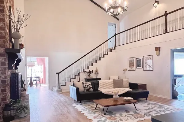 a living room with furniture a chandelier and a fireplace