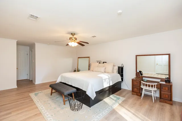 a spacious bedroom with a bed and a chandelier