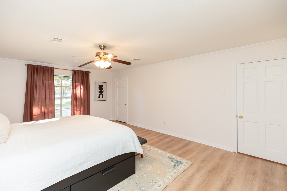 1210 Nottingham Lane Beaumont, TX 77706 - Photo 26 of 50 a spacious bedroom with a bed and a chandelier