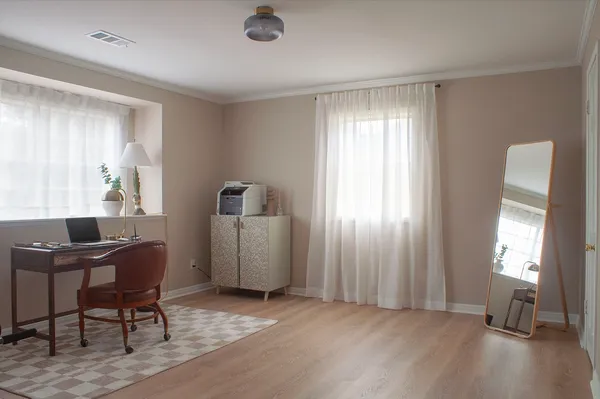 a view of a workspace with furniture and a window