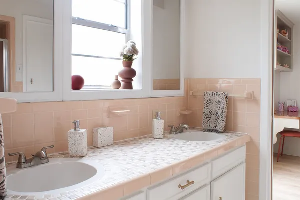 a white toilet sitting next to a bathroom sink and a mirror