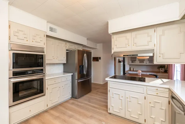 a kitchen with granite countertop cabinets stainless steel appliances and a counter space
