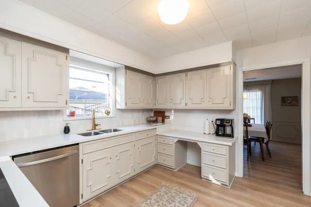 a kitchen with cabinets appliances a sink and a window