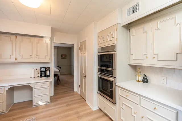 a kitchen with granite countertop a refrigerator and a stove top oven