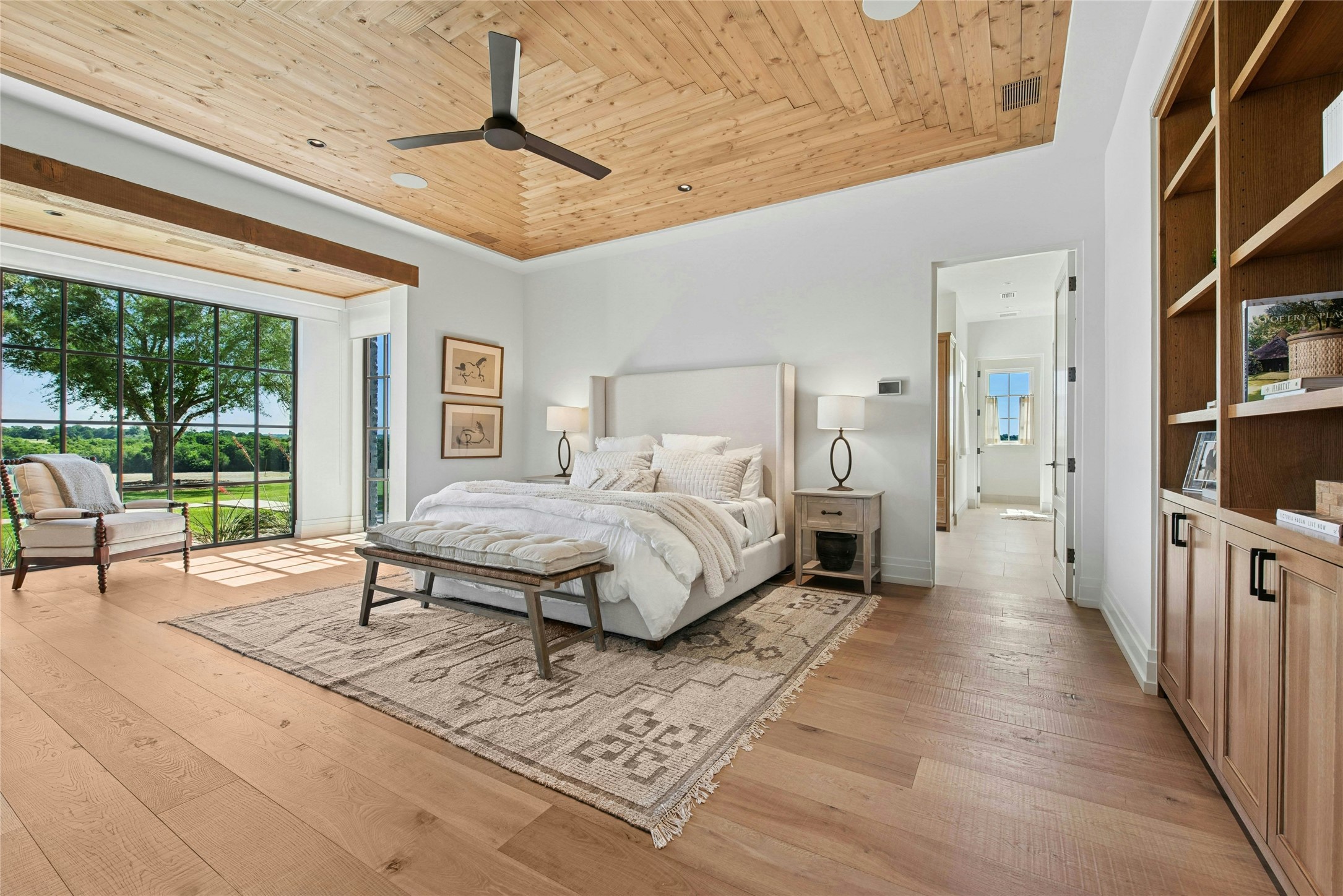 658 Fordtran Road New Ulm, TX 78950 - Photo 17 of 50 a spacious bedroom with a bed a table and large window with garden view