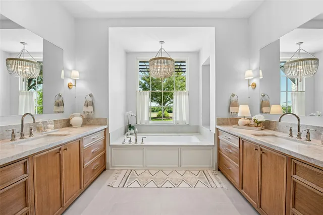 a spacious bathroom with a tub sink and mirror