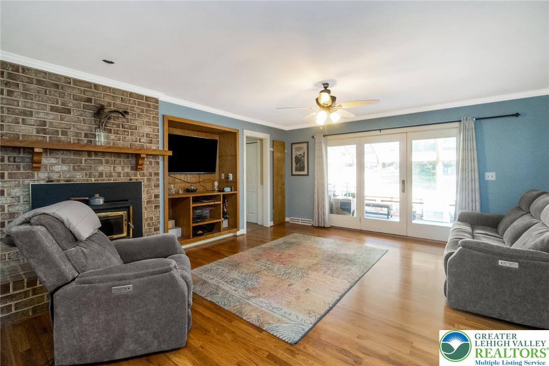 1553 Surrey Road Bethlehem, PA 18015 - Photo 21 of 92 A comforting living space features a cozy fireplace and gleaming hardwood flooring.