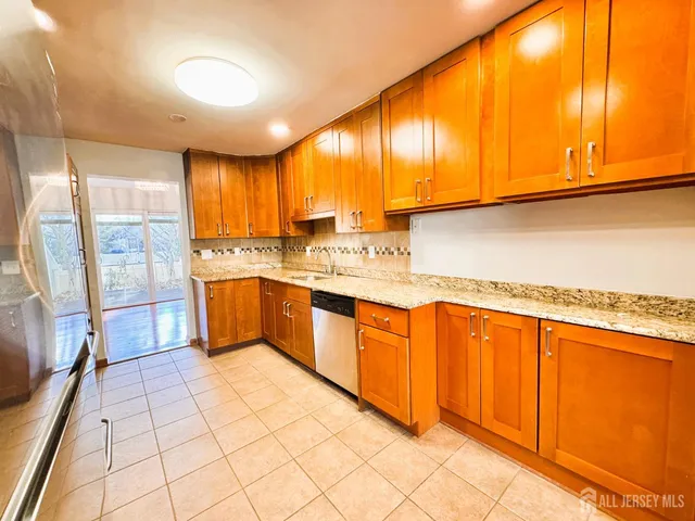 a kitchen with stainless steel appliances a sink window and cabinets