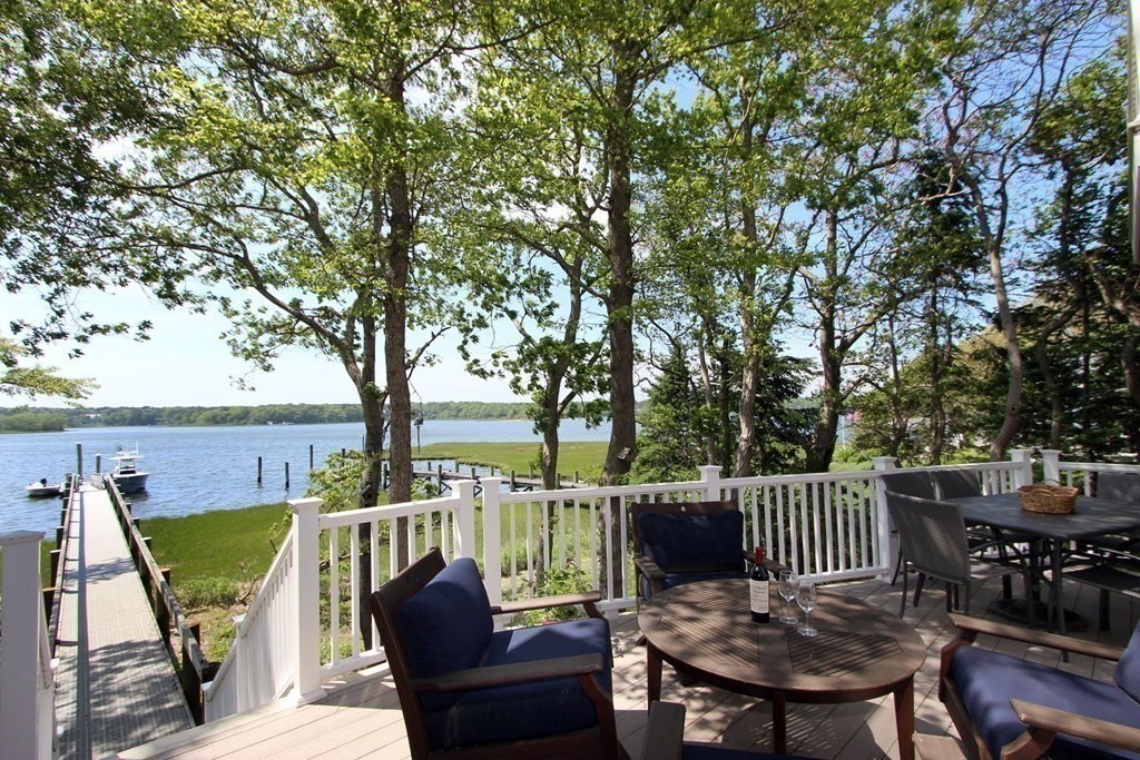 99 Monomoscoy Road West Mashpee, MA 02649 - Photo 2 of 40 a view of a deck with two chairs and a table