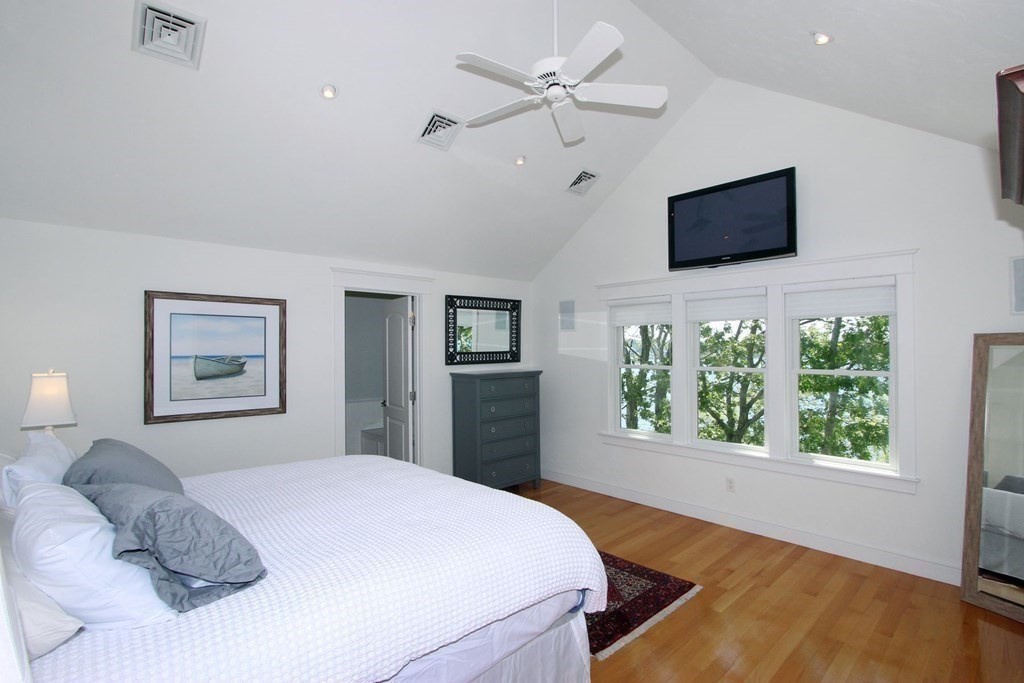 99 Monomoscoy Road West Mashpee, MA 02649 - Photo 22 of 40 a bedroom with a large bed and a flat screen tv