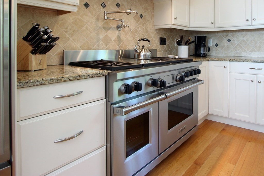 99 Monomoscoy Road West Mashpee, MA 02649 - Photo 27 of 40 a kitchen with granite countertop white cabinets and white appliances
