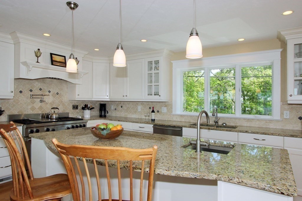 99 Monomoscoy Road West Mashpee, MA 02649 - Photo 28 of 40 a kitchen with a stove a sink a center island and windows