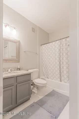 a bathroom with a granite countertop sink a toilet and a mirror