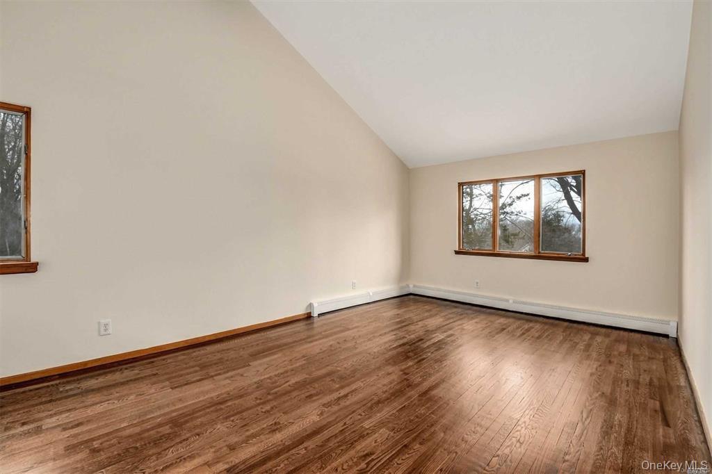 36 Bevin Road Northport, NY 11768 - Photo 13 of 26 Unfurnished room with wood finished floors, a baseboard radiator, and high vaulted ceiling