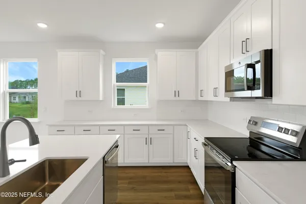 a kitchen with stainless steel appliances granite countertop a sink and a stove