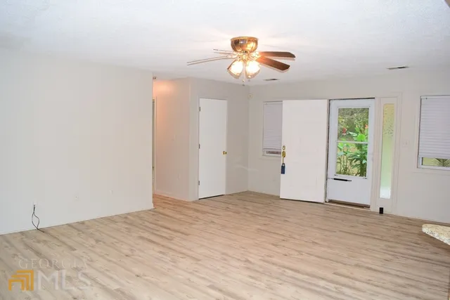 a view of empty room with wooden floor