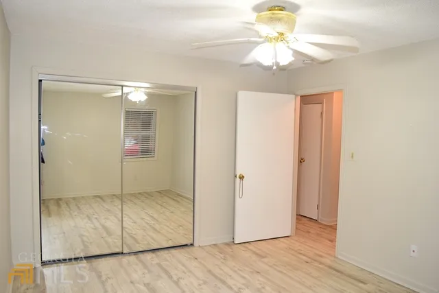 wooden floor in an empty room with a bathroom