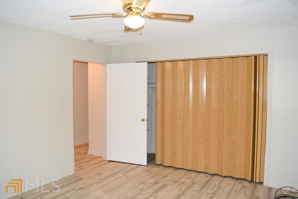 672 Andrew Bailey Road Sharpsburg, GA 30277 - Photo 19 of 34 an empty room with wooden floor closet and windows