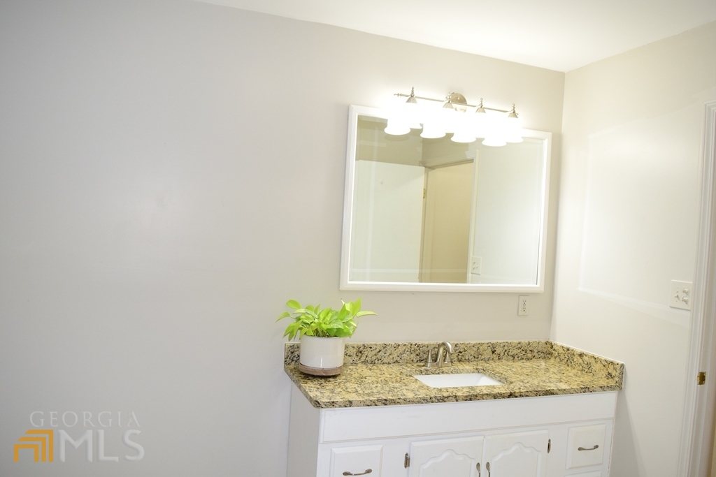 672 Andrew Bailey Road Sharpsburg, GA 30277 - Photo 23 of 34 a bathroom with a granite countertop sink and a mirror