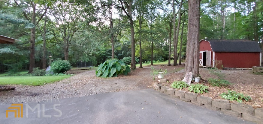 672 Andrew Bailey Road Sharpsburg, GA 30277 - Photo 33 of 34 a backyard of a house with a garden and outdoor seating