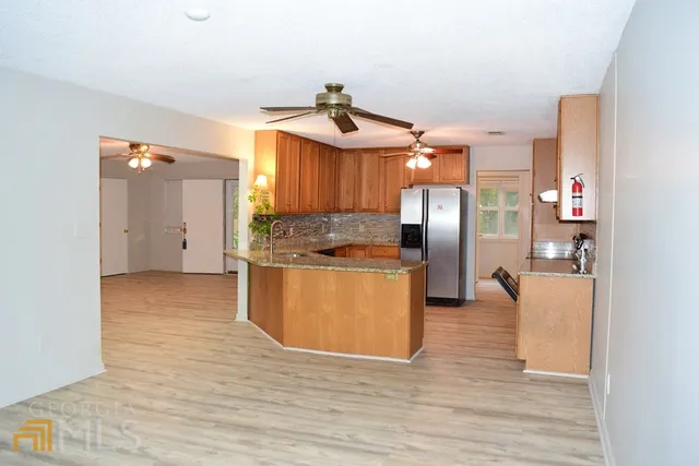 a kitchen with stainless steel appliances granite countertop a refrigerator a sink a stove and oven