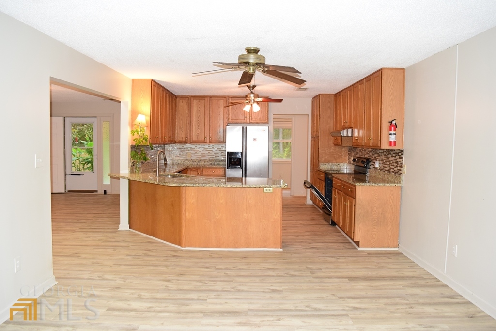 672 Andrew Bailey Road Sharpsburg, GA 30277 - Photo 10 of 34 a view of a kitchen with kitchen island a counter top space a sink a refrigerator and a view of living room