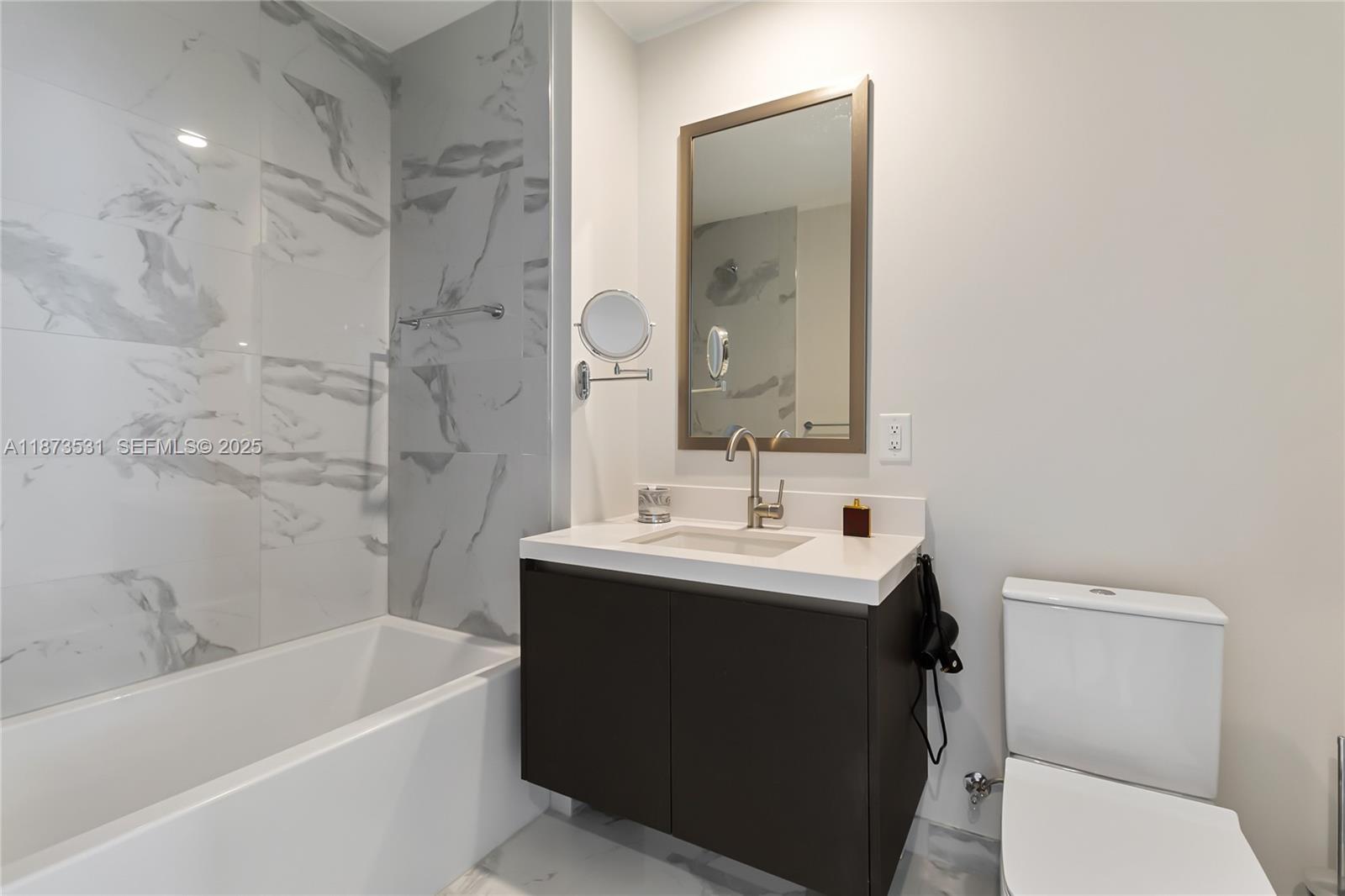 851 Northeast 1st Avenue, Unit 1611 Miami, FL 33132 - Photo 15 of 47 a bathroom with a sink a toilet and a bathtub