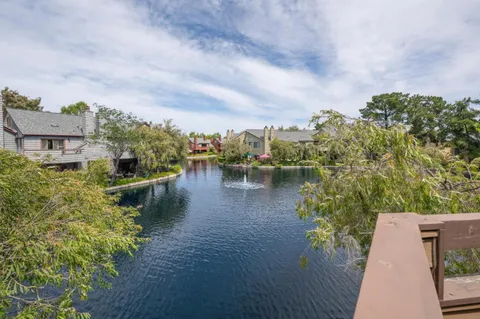 a backyard of a house with lots of green space and wooden fence