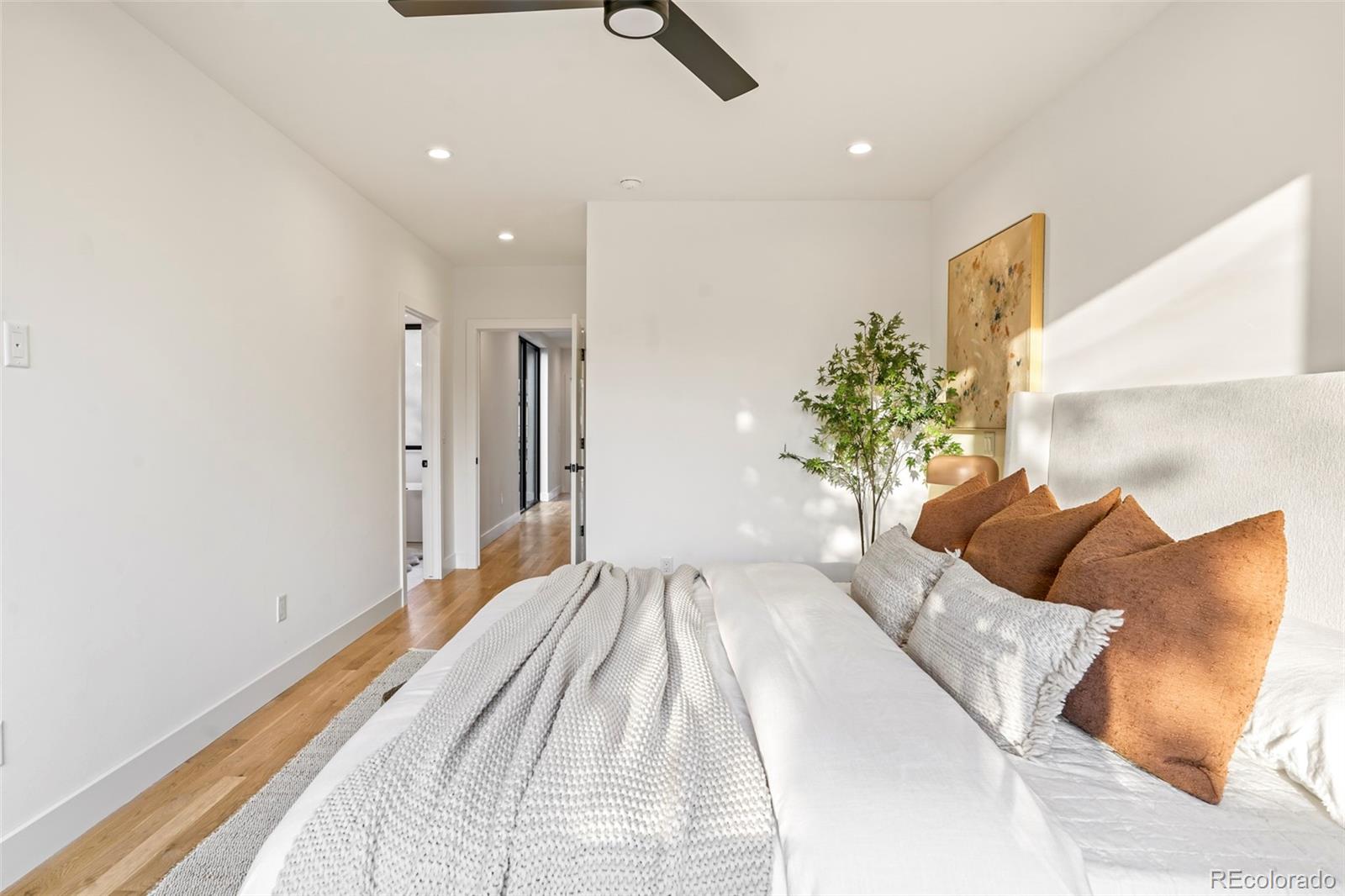 4449 Stuart Street Denver, CO 80212 - Photo 21 of 44 a bedroom with a large bed and a potted plant
