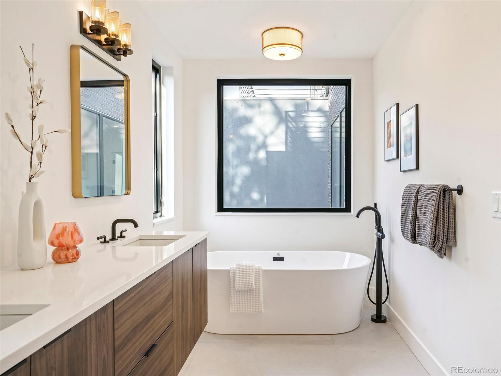 4449 Stuart Street Denver, CO 80212 - Photo 23 of 44 a bathroom with a tub a sink and mirror