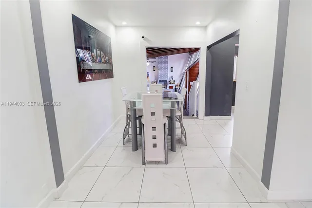 a kitchen with stainless steel appliances granite countertop a refrigerator a stove a sink and a white cabinets