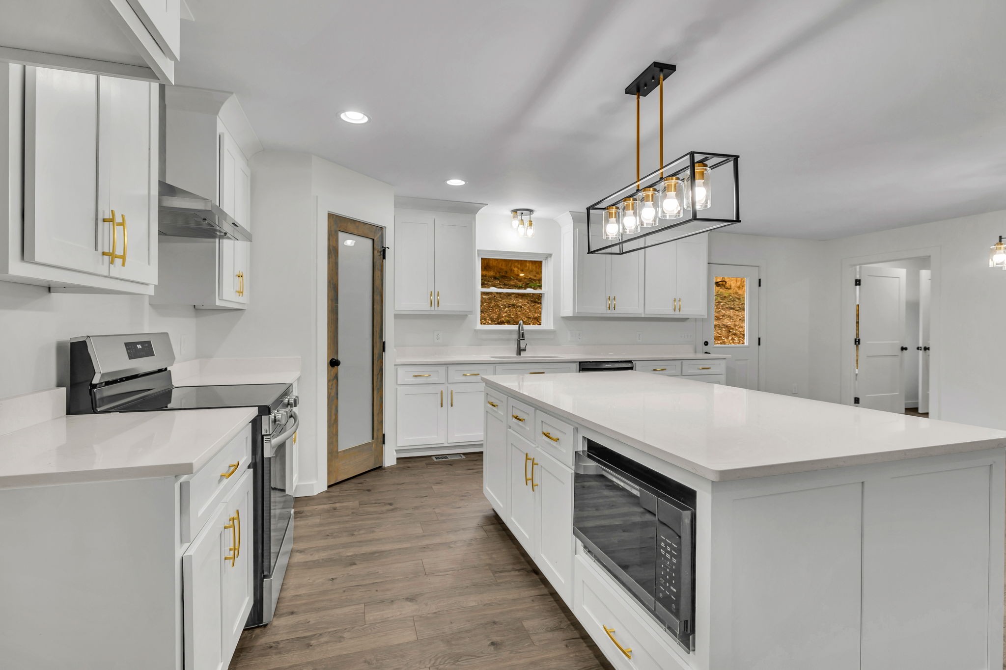 a kitchen that has a lot of cabinets in it and wooden floors