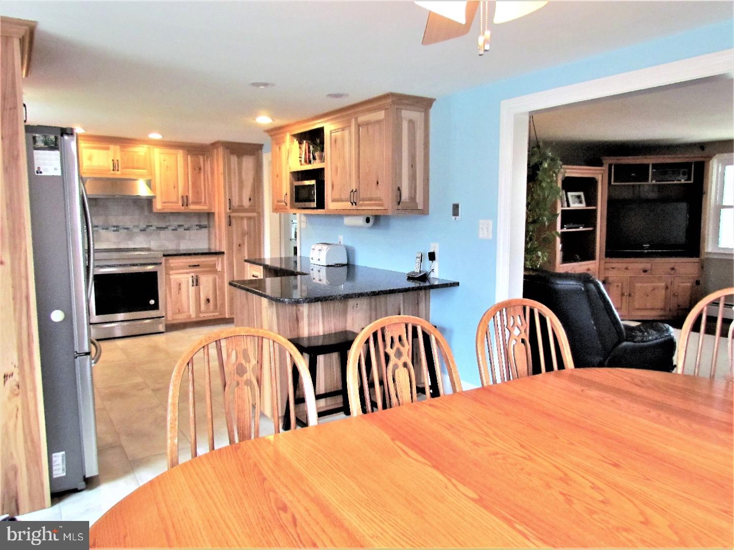 21 Woodside Road Perkasie, PA 18944 - Photo 5 of 25 a large white kitchen with granite countertop a stove a sink a dining table and chairs