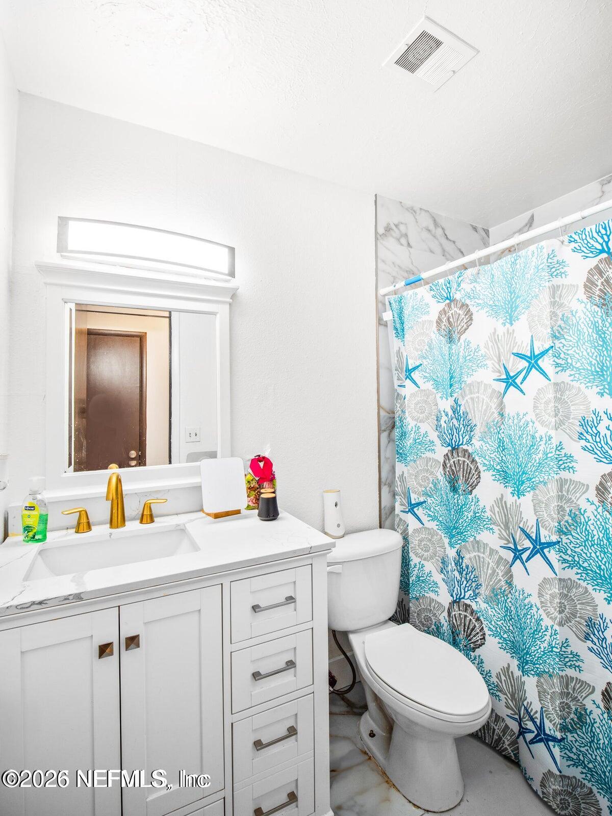 856 Palermo Road Jacksonville, FL 32216 - Photo 12 of 17 a bathroom with a sink vanity mirror and toilet