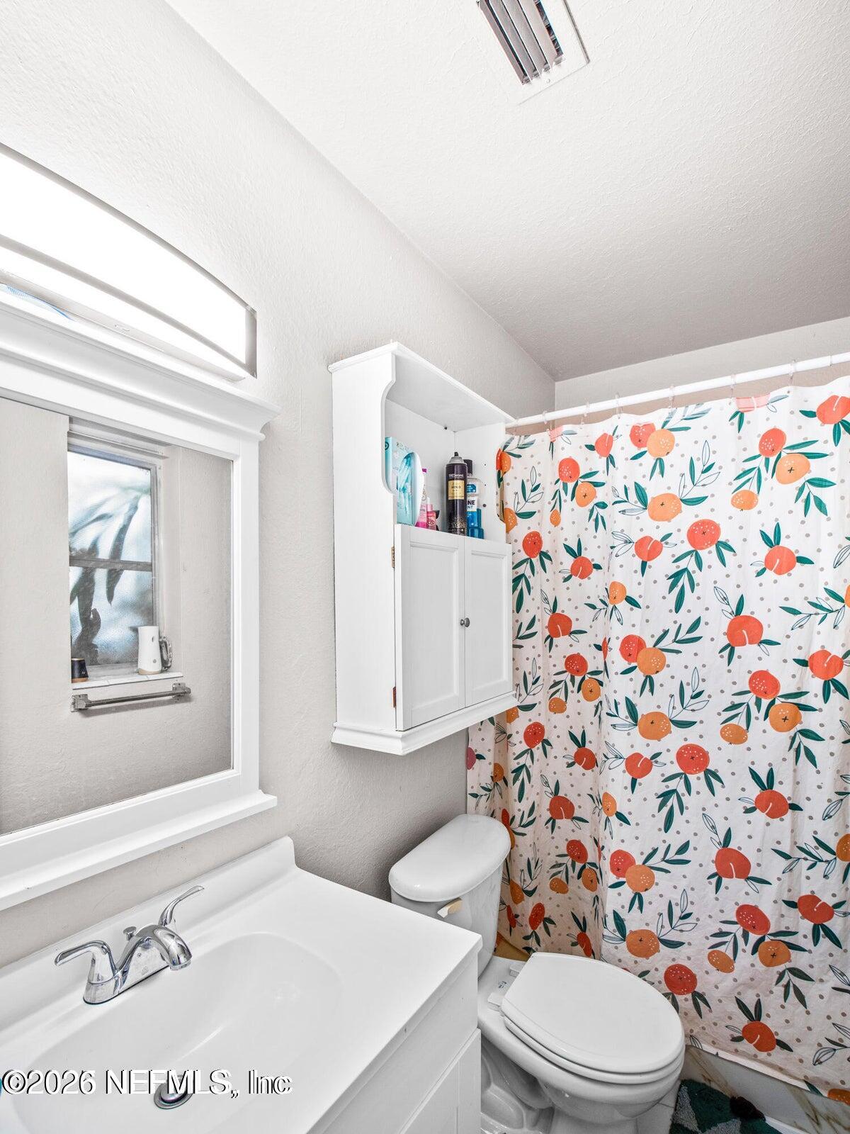 856 Palermo Road Jacksonville, FL 32216 - Photo 10 of 17 a white toilet sitting next to a shower curtain