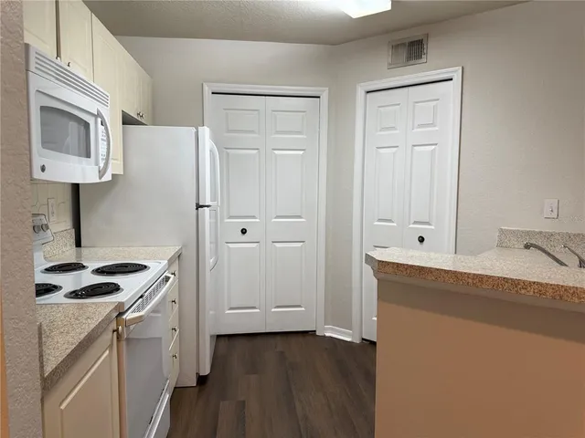 a kitchen with a sink cabinets and wooden floor