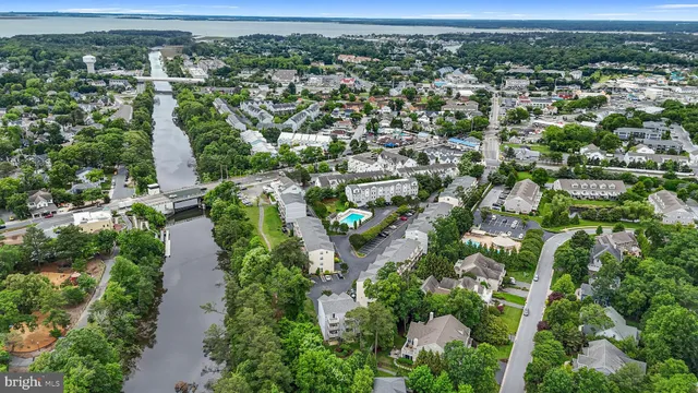 an aerial view of residential houses with outdoor space and trees