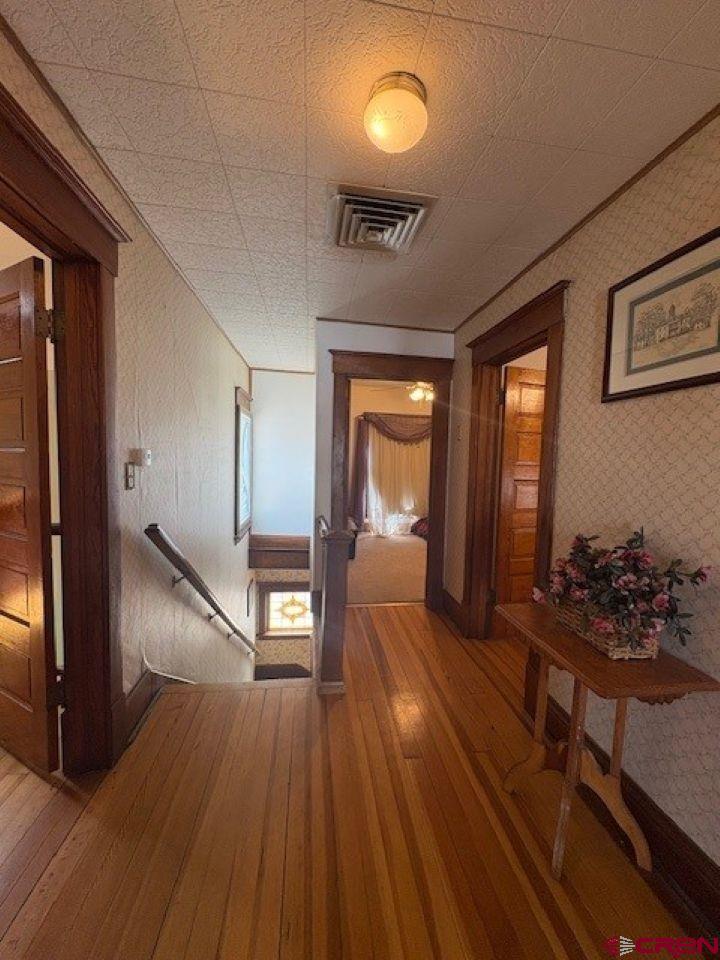 184 Garnet Avenue Delta, CO 81416 - Photo 21 of 36 a view of a hallway to a livingroom with wooden floor and furniture
