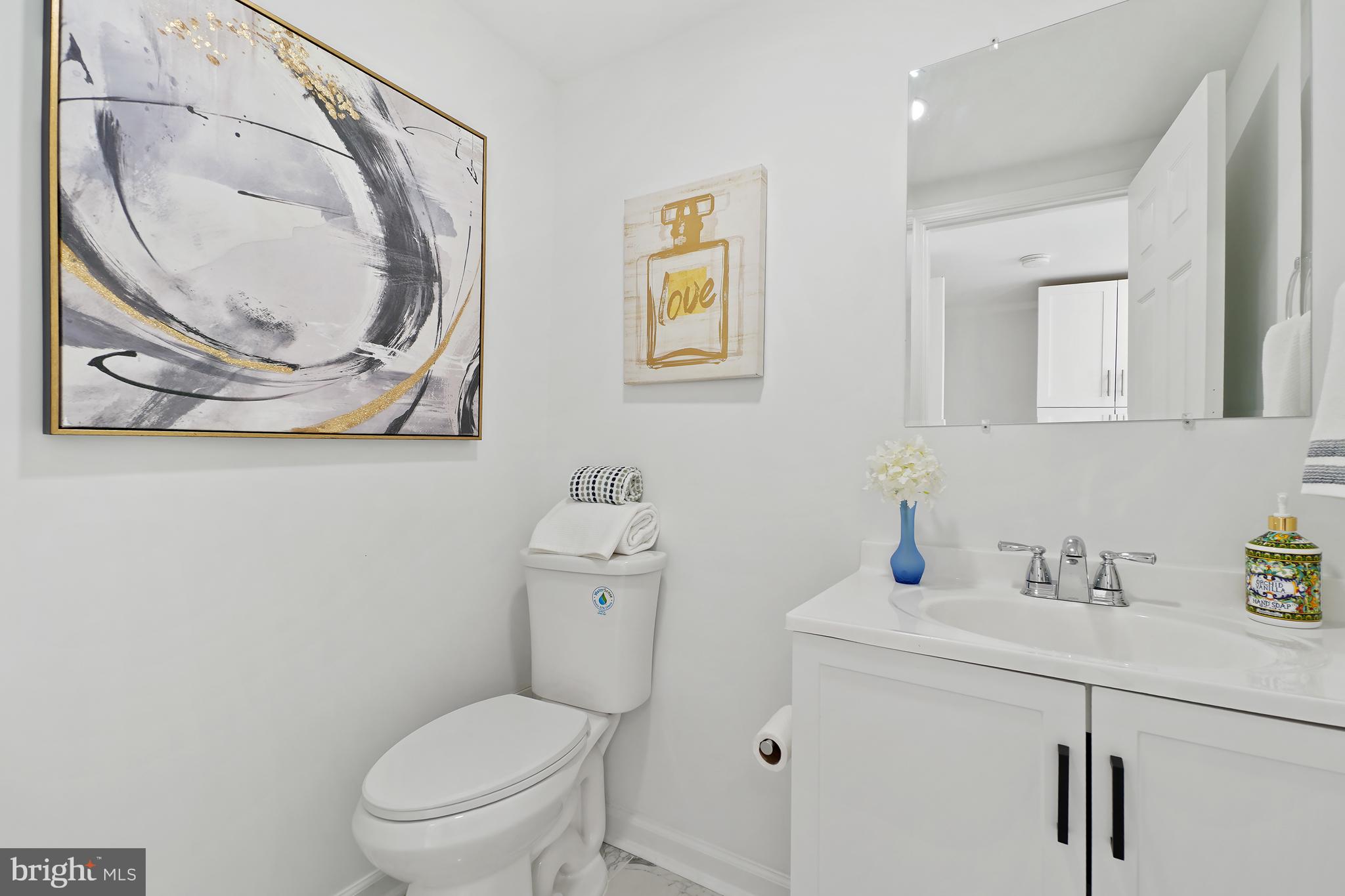 3731 Falls Road Baltimore, MD 21211 - Photo 16 of 30 a bathroom with a sink a toilet and a mirror