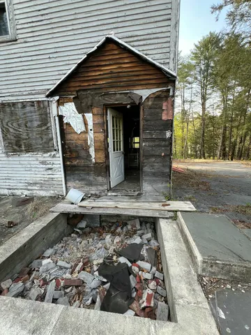 a view of an empty room with wooden floor and windows