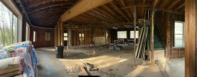 a view of an empty room with wooden floor and windows